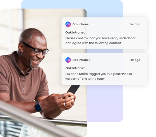 Man smiling at phone with Oak Intranet must-read document notifications displayed.