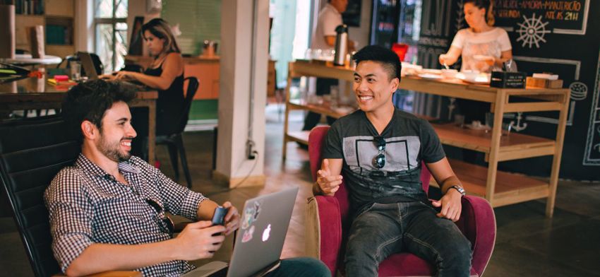Two men having a chat and laughing at work