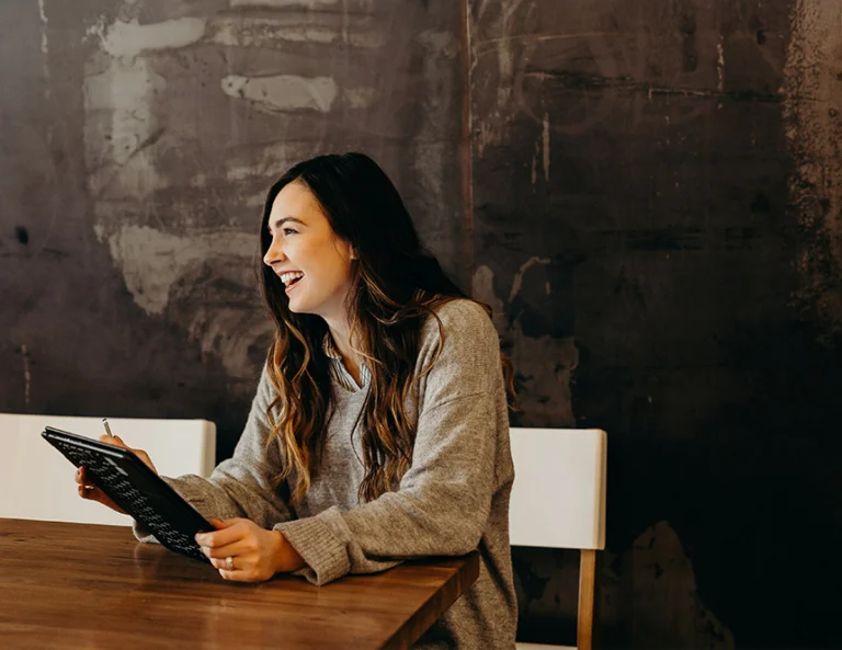 person smiling looking at tablet