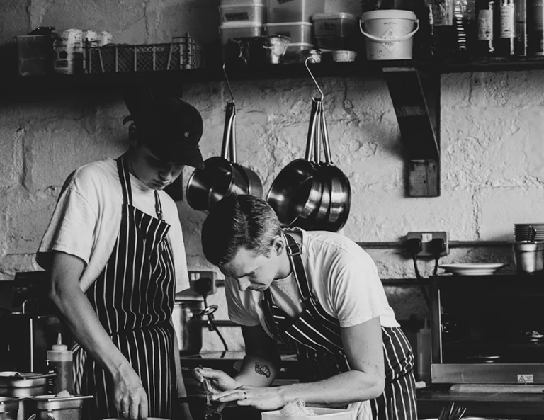 black and white image of two kitchen staff members working